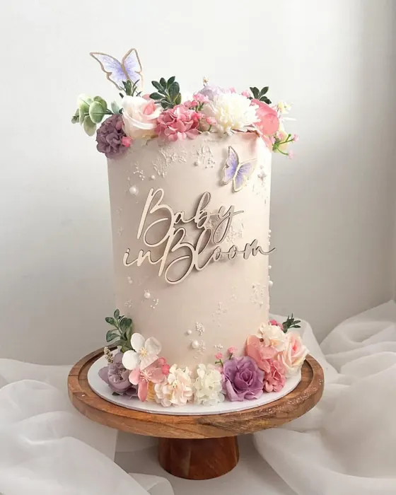 Baby in bloom cake with pastel flowers